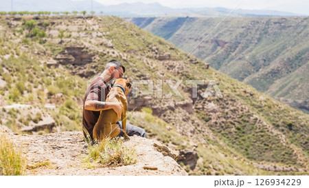Man hugging his dog while enjoying the view in gorafe, spain 126934229