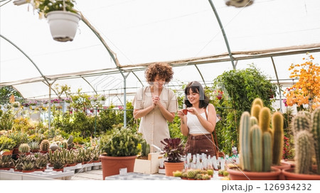 Two female customers choosing plants in greenhouse 126934232