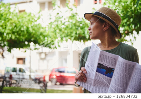 Woman Outdoors Reading a Magazine in a Relaxed Park Setting Woman Outdoors Reading a Magazine in a Relaxed Park Setting 126934732