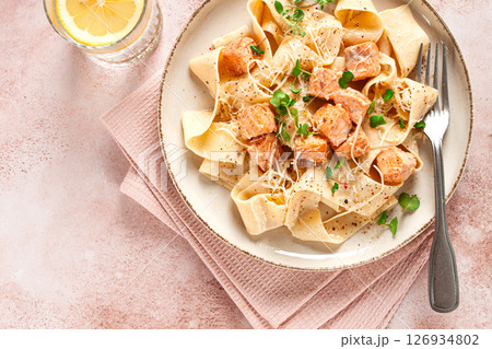 tagliatelli pasta, with salmon slices and herbs, on a decorative plate, homemade, no people tagliatelli pasta, with salmon slices and herbs, on a decorative plate, homemade, no people 126934802