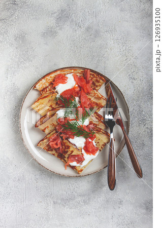 Delicious pancakes with salmon and sour cream , breakfast, on a plate, rustic style ,with cutlery 126935100