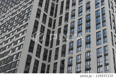 Facade of a modern high-rise building with cheap apartments and small balconies 126935150