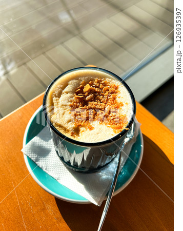 Nice Texture of Latte art on hot latte coffee . Milk foam with sweet topping. Latte art from professional barista artist. Vertical. 126935397