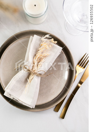 Elegant minimal table setting with wheat decoration in neutral tones 126935502