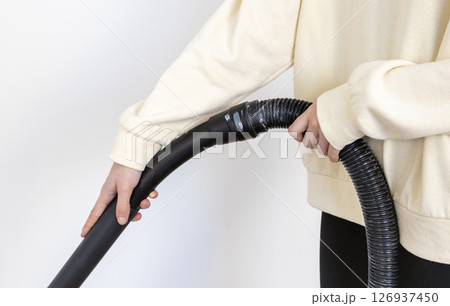 Close-up of a woman cleaning her apartment with a professional vacuum cleaner. 126937450