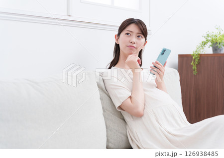 スマホを使う妊婦（悩む・考える） 126938485