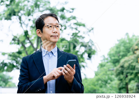 屋外でスマホを操作するビジネスマン 126938924