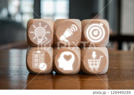 Wooden blocks displaying icons representing stages of a conversion funnel for marketing and sales strategy. Wooden blocks displaying icons representing stages of a conversion funnel for marketing and sales strategy. 126940289