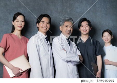 カッコイイグレイヘアの医者と複数のドクターのイメージ　笑顔のカメラ目線 126940593