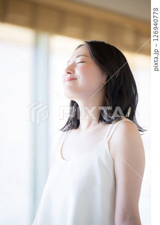 寝起きで深呼吸などする女性 126940778
