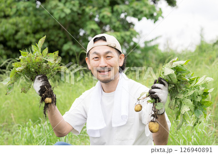 畑でジャガイモを育てる男性　農家や農業で働くする人のイメージ　カメラ目線	 126940891