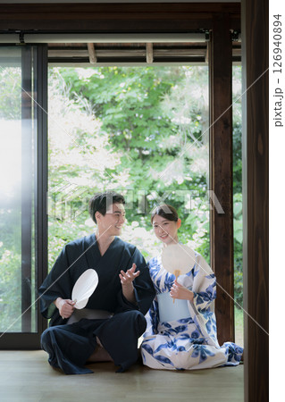 緑が美しい縁側でくつろぐ浴衣の男性と美しい女性 旅行や旅館などの湯上り温泉のイメージ 縦 緑が美しい縁側でくつろぐ浴衣の男性と美しい女性 旅行や旅館などの湯上り温泉のイメージ 縦 126940894