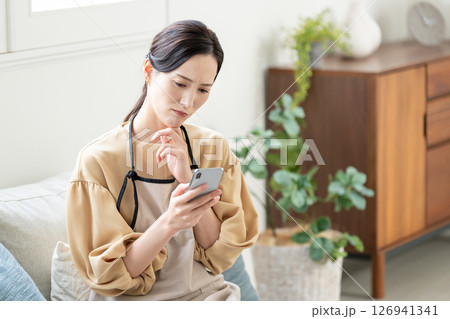 スマホを見ながら悩む女性 126941341