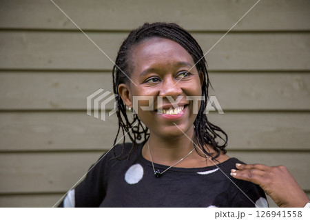 Smiling African Woman Looking Aside with Hand on Shoulder Outdoors 126941558