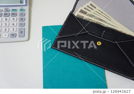 デスク上の電卓と一万円札が入った財布 126941627