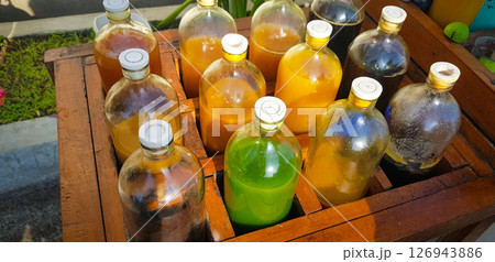 Colorful Bottles of traditional natural organic medicine locally called jamu, Displayed in Wooden Case on a Sunny Day 126943886
