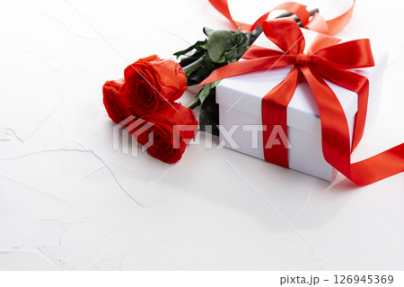 赤いリボンのギフトボックスと赤いバラの花束とコピースペース 赤いリボンのギフトボックスと赤いバラの花束とコピースペース 126945369