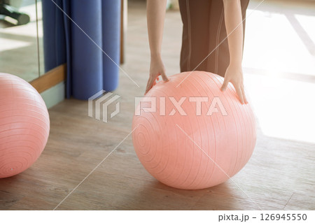 closeup women hand holding fitness ball in sport club with morning gentle light closeup women hand holding fitness ball in sport club with morning gentle light 126945550