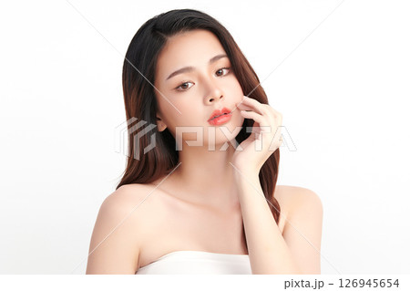 A beautiful young Asian woman with clean, fresh skin against a white background. Skincare, facial treatment, cosmetology, beauty, and spa. An elegant portrait of an Asian woman. 126945654