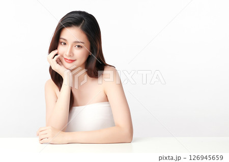 A beautiful young Asian woman with clean, fresh skin against a white background. Skincare, facial treatment, cosmetology, beauty, and spa. An elegant portrait of an Asian woman. 126945659