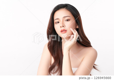 A beautiful young Asian woman with clean, fresh skin against a white background. Skincare, facial treatment, cosmetology, beauty, and spa. An elegant portrait of an Asian woman. 126945660
