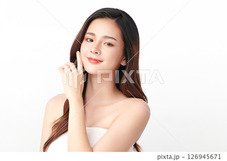 A beautiful young Asian woman with clean, fresh skin against a white background. Skincare, facial treatment, cosmetology, beauty, and spa. An elegant portrait of an Asian woman. 126945671