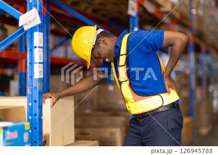 worker back pain, african male worker working in warehouse storage suffering from muscle problem 126945788