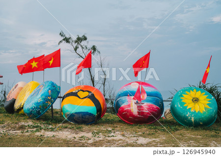 Painted round traditional fishing Vietnamese boats Thung Chai and flags of Vietnam in Murals Paintings Village 126945940