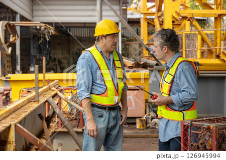 Construction engineer team working together join teamwork talking together at construction site 126945994