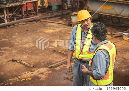 Construction engineer team working together join teamwork talking together at construction site 126945996