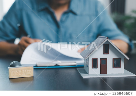 Female real estate broker presenting and advised to model home, building project detail in office, sign purchase sales application contract, agreements concerned mortgage loan offer and insurance. Female real estate broker presenting and advised to model home, building project detail in office, sign purchase sales application contract, agreements concerned mortgage loan offer and insurance. 126946607