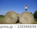 大きな干し草ロールの上に立つ少年 126946698