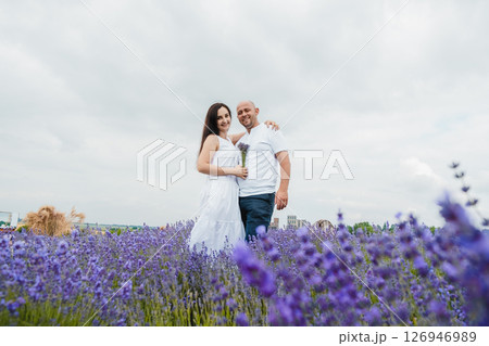 A young man gently embraces his beautiful wife among purple lavender A young man gently embraces his beautiful wife among purple lavender 126946989
