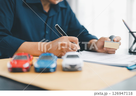 Businesswoman hand stamp approve on financial business approval document paper. Man hand accept permit contract agreement. Broker manager sign contract bank guarantee approved stamp application form 126947118