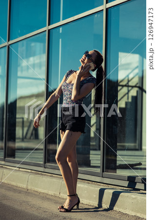 The girl at the glass wall looks focused, immersed in conversation The girl at the glass wall looks focused, immersed in conversation 126947173