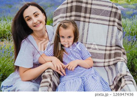 A girl in a beautiful purple dress sits in a rocking chair A girl in a beautiful purple dress sits in a rocking chair 126947436