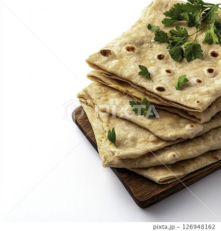 Freshly Made Thin Flatbread with Herbs on a White Background for Culinary Use 126948162