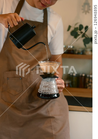 Man preparing freshly brewed coffee using a drip method at home Man preparing freshly brewed coffee using a drip method at home 126948895
