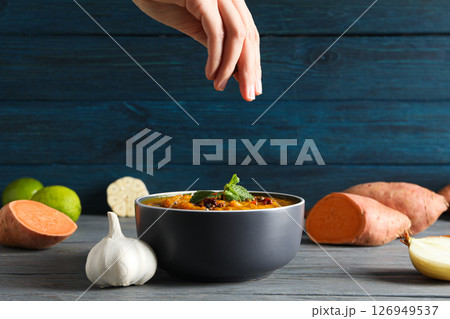 Sweet potato puree in bowl, ingredients and hand on wooden background 126949537