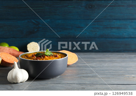Sweet potato puree in bowl and ingredients on wooden background, space for text 126949538