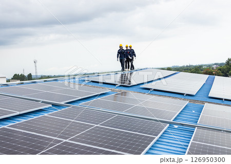 Worker walking inspection solar panels on the roof top of industry building, Large scale of solar energy system for green eco power supply Worker walking inspection solar panels on the roof top of industry building, Large scale of solar energy system for green eco power supply 126950300