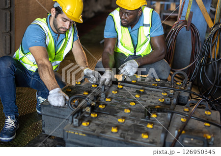 Engineer male workers working with old battery power supply using in train cabin heavy industry Engineer male workers working with old battery power supply using in train cabin heavy industry 126950345