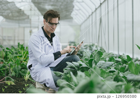 Scientist people working plant research in organic farm. Biologist study collecting plant grow data Scientist people working plant research in organic farm. Biologist study collecting plant grow data 126950380