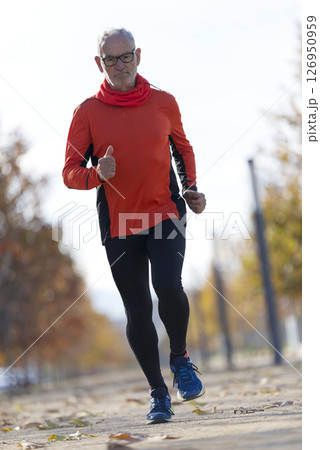 Senior man running outdoors in sportswear Senior man running outdoors in sportswear 126950959