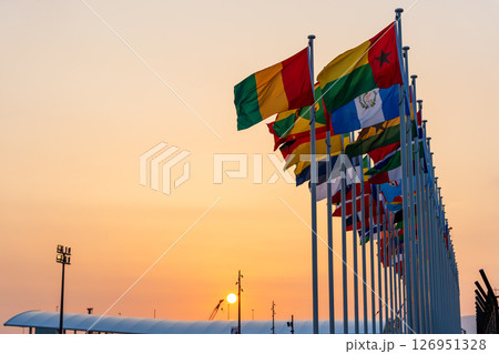 大阪関西万博会場入口、万国旗と夕日、EXPO 2025 126951328