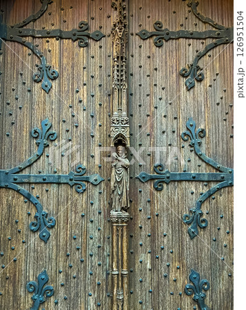 A stunning close-up of an aged wooden church door with detailed ironwork A stunning close-up of an aged wooden church door with detailed ironwork 126951504