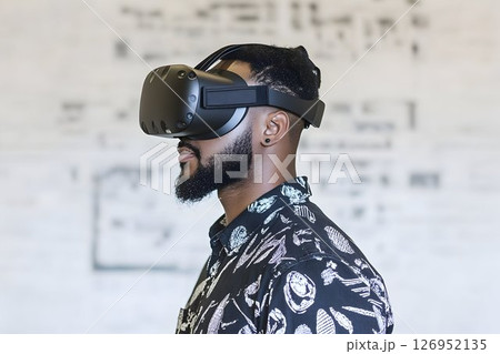 Afro-American man immersing himself in virtual reality experience, futuristic entertainment 126952135
