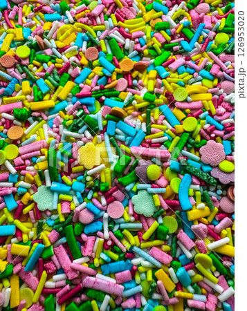 Multicolored small candies of different shapes. Top view. Bright vertical background Multicolored small candies of different shapes. Top view. Bright vertical background 126953020