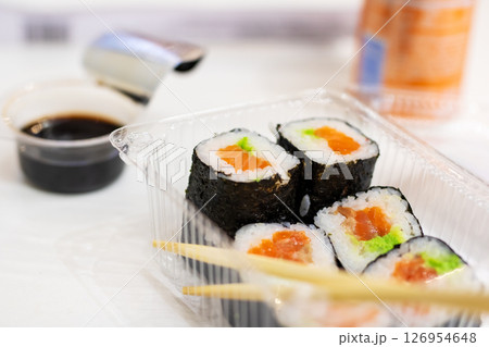 A plastic container filled with delicious sushi and chopsticks 126954648