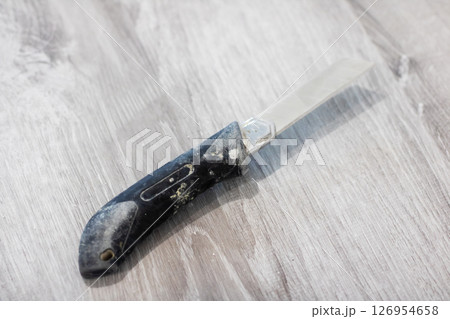 A Closeup of a Unique Folding Knife Displayed Elegantly on a Rustic Wooden Surface A Closeup of a Unique Folding Knife Displayed Elegantly on a Rustic Wooden Surface 126954658